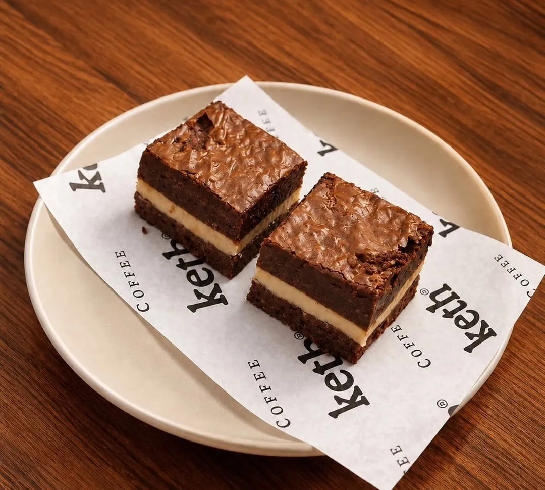 Two layered hazelnut brownies on a cream plate