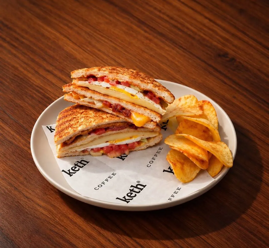 Toasted club sandwich with egg, cheese and tomato, with crisps