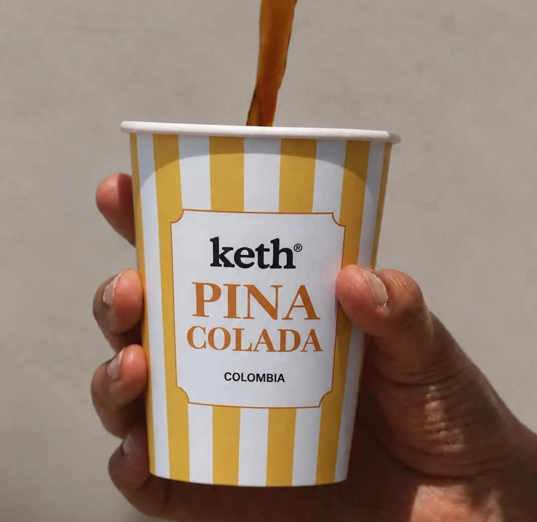 Coffee poured into a striped Keth Pina Colada cup held in the sun