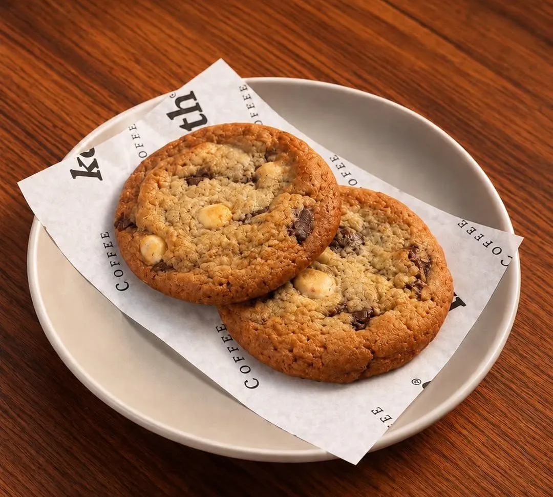 Two chunky cookies with chocolate pieces on Keth paper